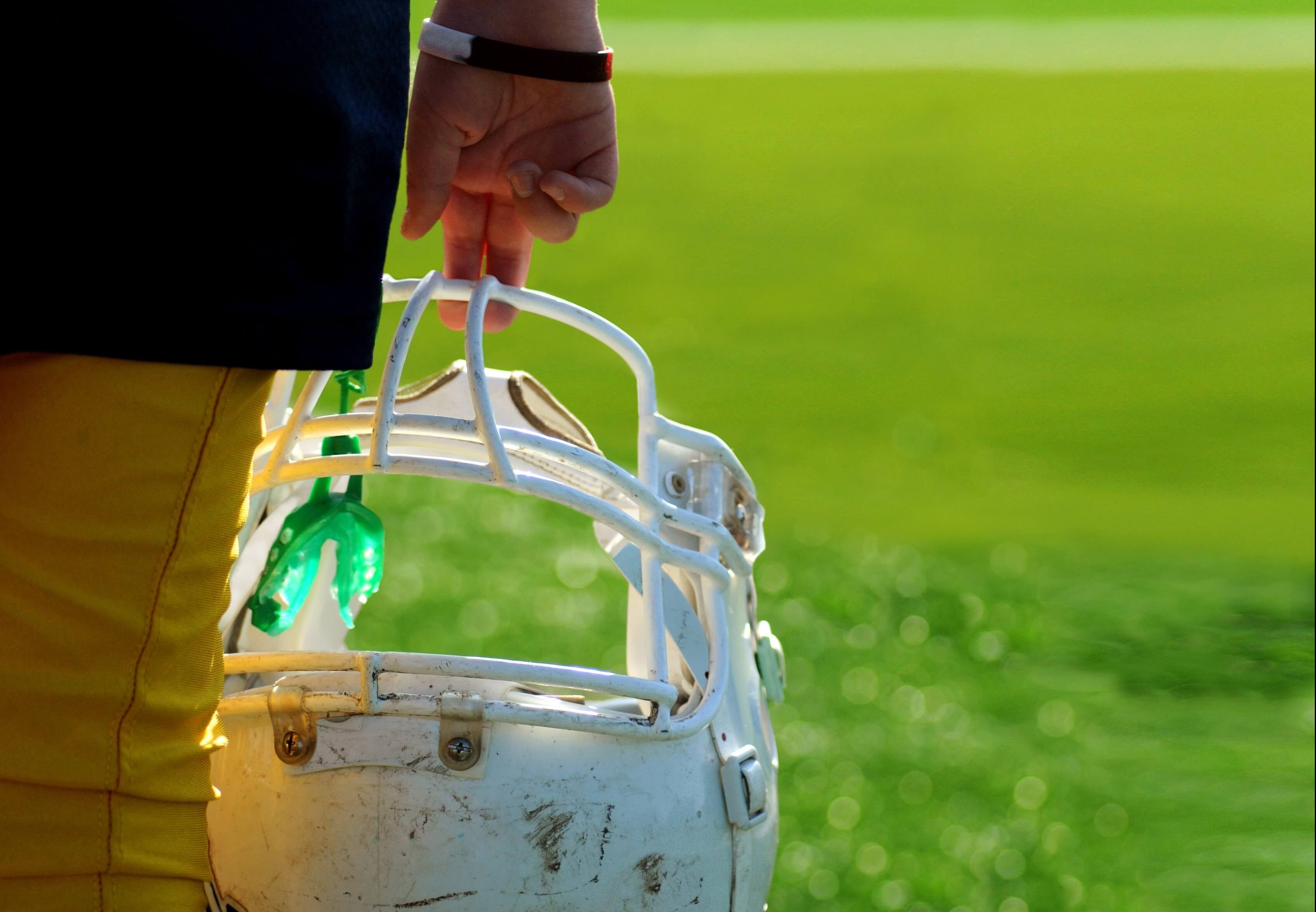 player holding football helmet