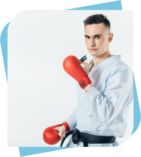 Man in a karate gi and black belt holding a mouth guard.