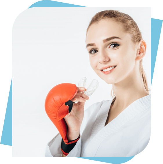 Woman with martial arts gloves holding a mouth guard.