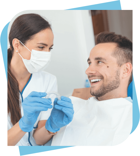 Man smiling at his dentist as she gives him a new mouth guard.