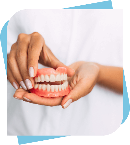 Dental Assistant holding top and bottom complete dentures.