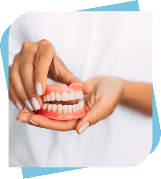 Dental Assistant holding top and bottom complete dentures.