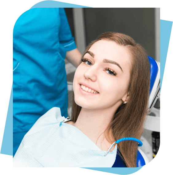 Teenage girl sitting in a dental chair smiling after teeth cleaning.