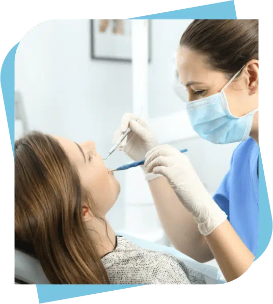 Dentist checking a woman's teeth during teeth cleaning.