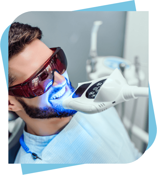 Man with UV goggles getting teeth whitening.