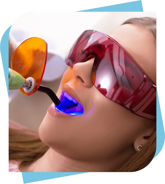Patient wearing UV goggles while having a filling cured with a curing gun.