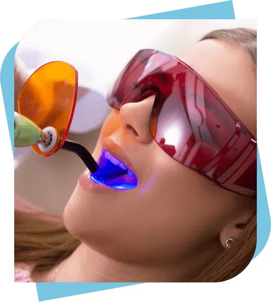 Patient wearing UV goggles while having a filling cured with a curing gun.