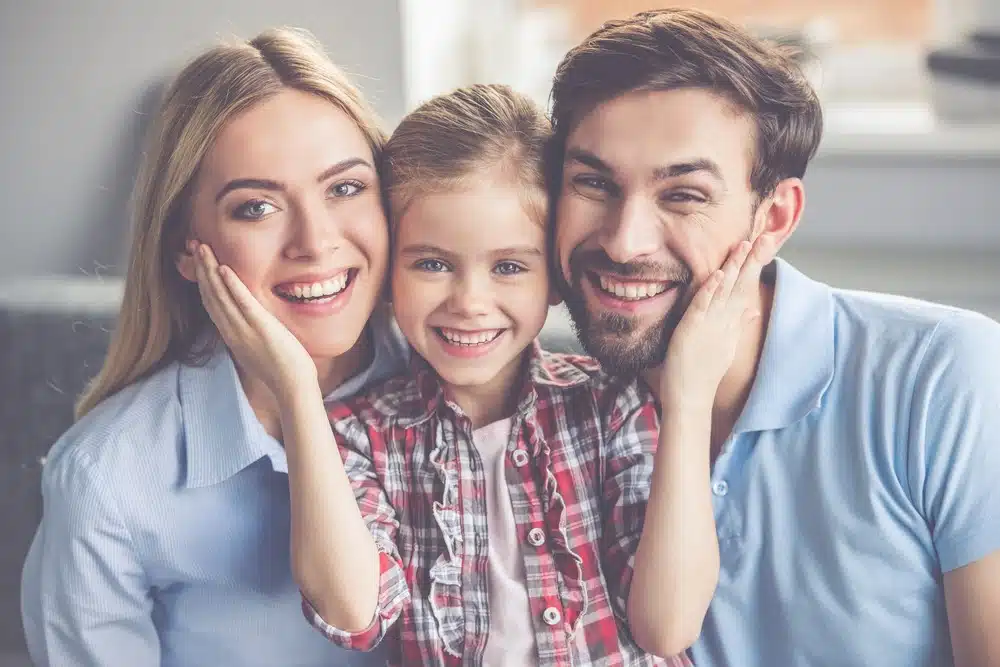 family smiling thanks to proper dental hygiene