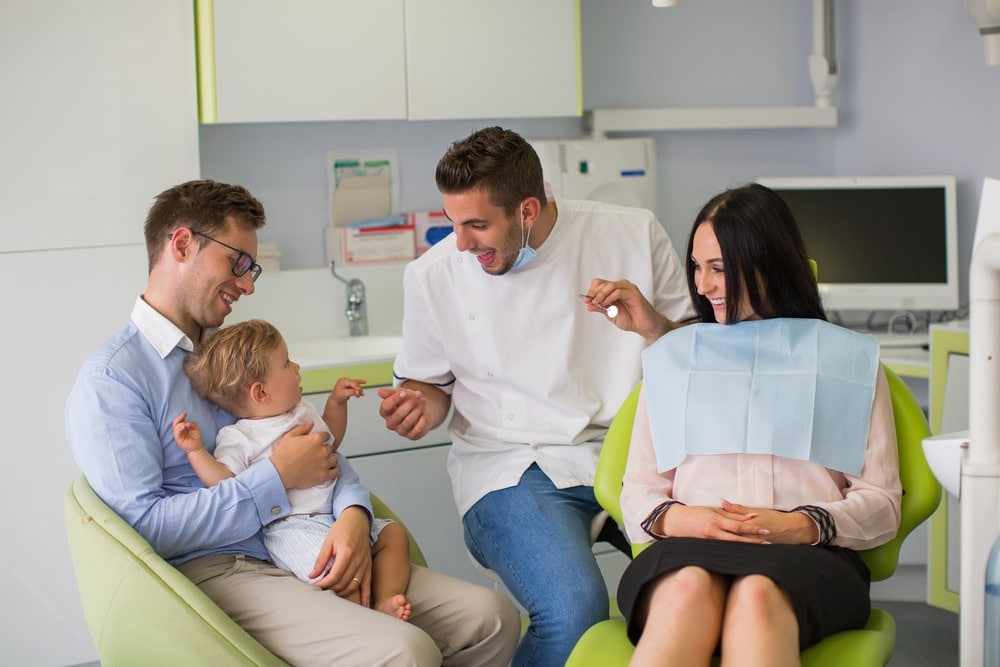 a family visiting their dentist with a small child