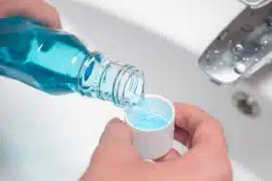 person holding open bottle of mouthwash
