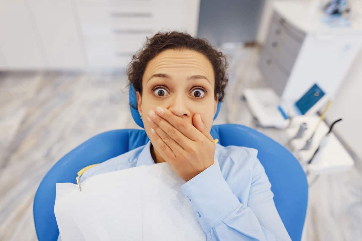 woman nervous about dental treatment while sitting in dental office