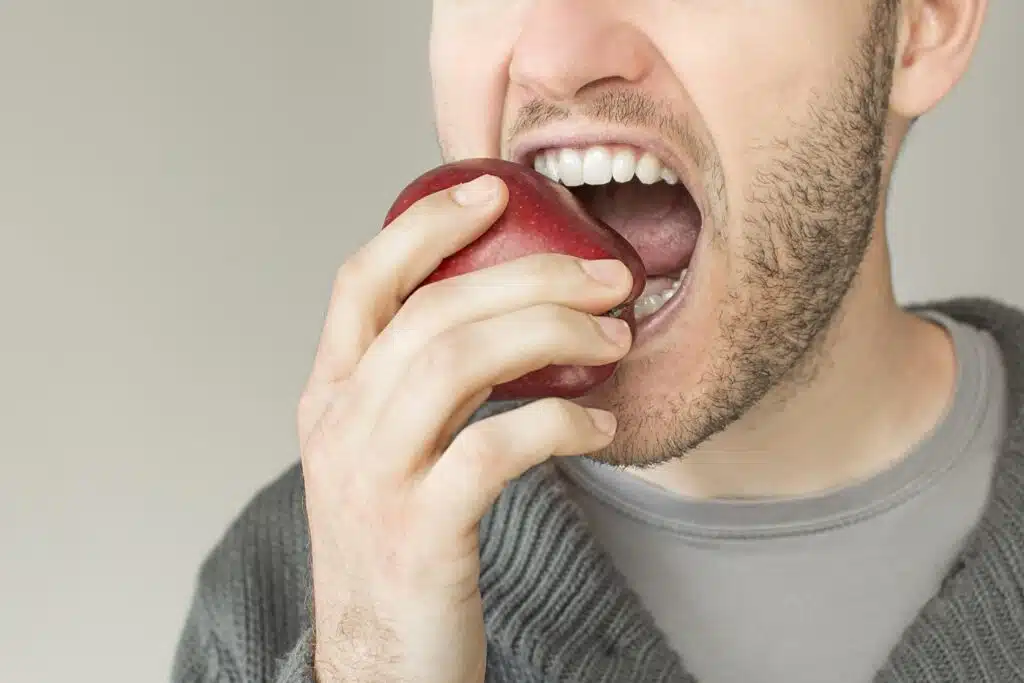 Closeup of a mouth biting an apple