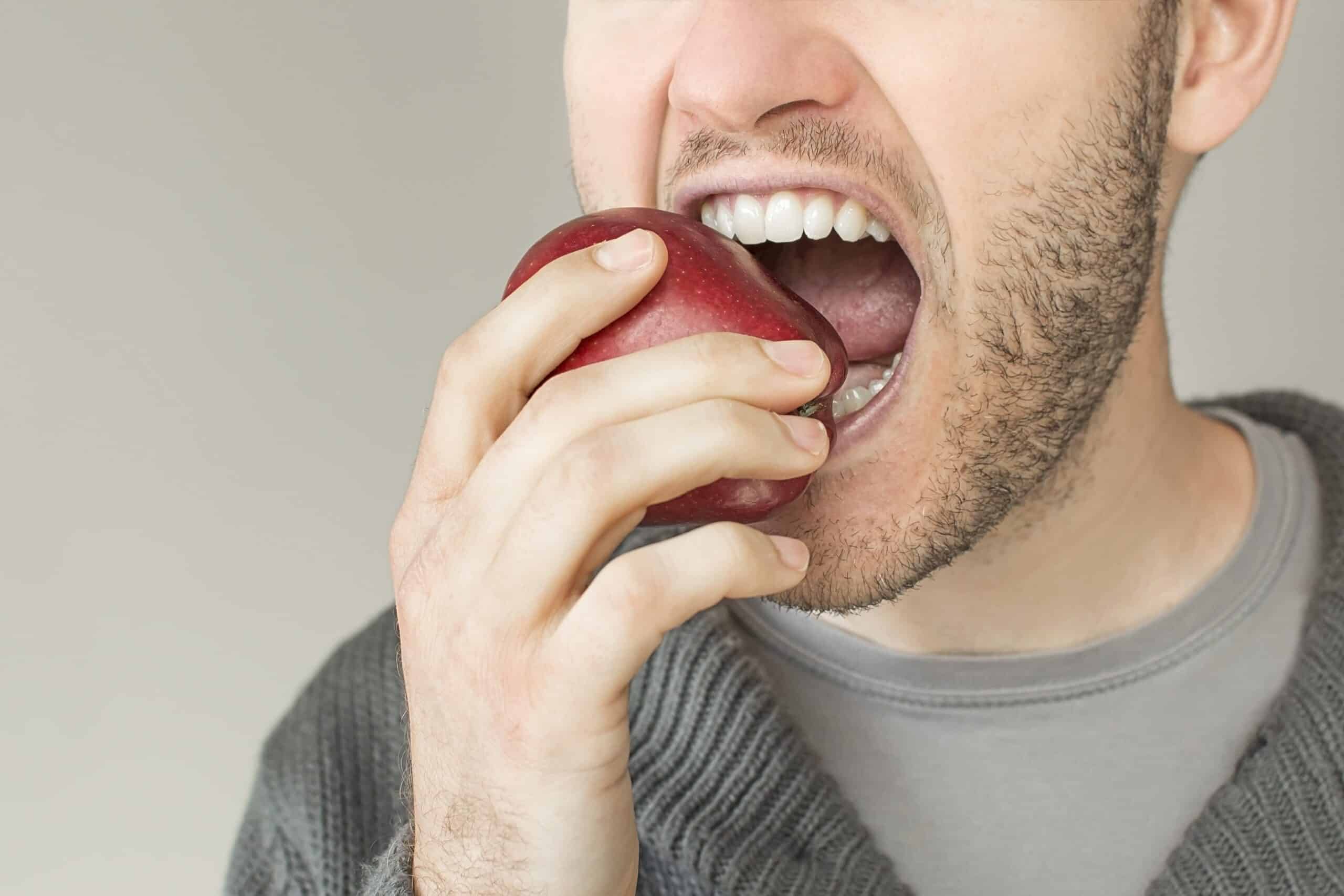 Closeup of a mouth biting an apple